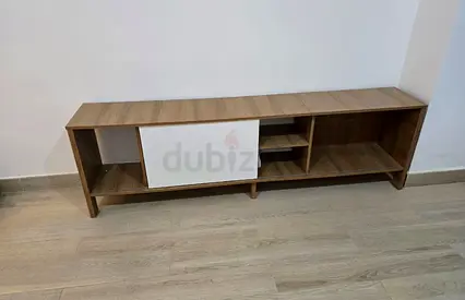 Low wooden TV unit with sliding white door