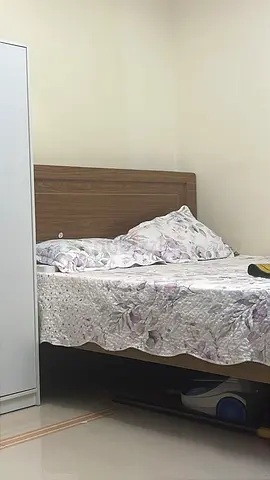 Wooden double bed frame with mattress and linens