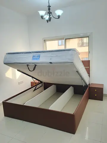 Brown hydraulic storage bed with mattress and bedside tables