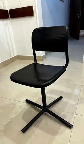 Black swivel desk chair — compact plastic seat with cross base (used)