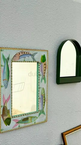 Two decorative wall mirrors — fish-frame and arched green mirror