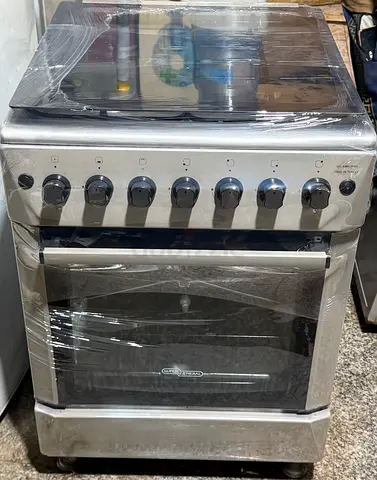 Freestanding stainless steel cooker with oven and hob