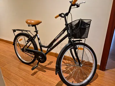 Spartan city bicycle step through frame with front basket, rear carrier and helmet. Black color