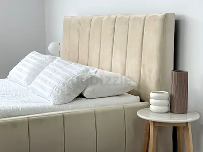 Beige upholstered bed frame with tall channel headboard