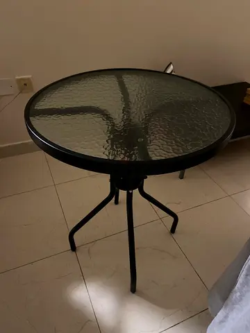 Round glass-top bistro table with metal frame — used
