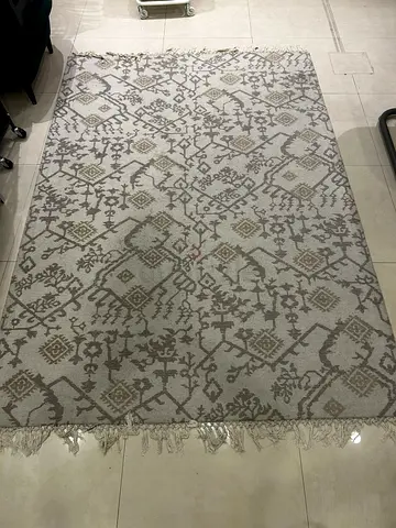 Light beige patterned area rug with fringe