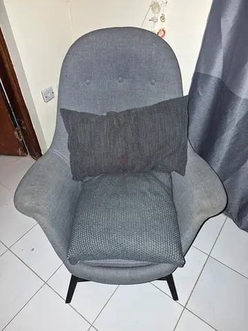 Grey upholstered accent armchair with cushions