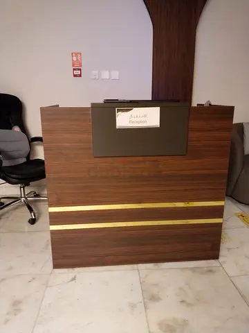 Used wooden reception desk with gold trim
