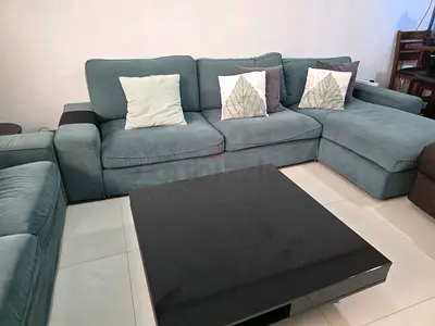 L-shaped teal fabric sectional sofa with coffee table