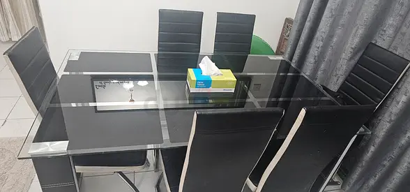 Glass dining table with 6 black chairs