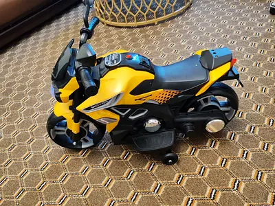 My yellow kids ride-on motorcycle toy with training wheels, suitable for 1 to 3 years.