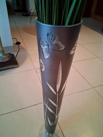 Tall silver metal floor vase with etched butterfly design and faux grass