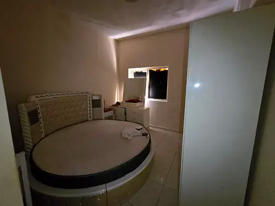 One bedroom and living room for annual rent in Emirates City, featuring high-end finishes, central gas, central air conditioning, 24-hour security,