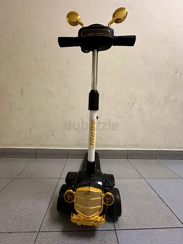 My kids black  gold 3-wheel ride-on scooter — good condition and has lights and music