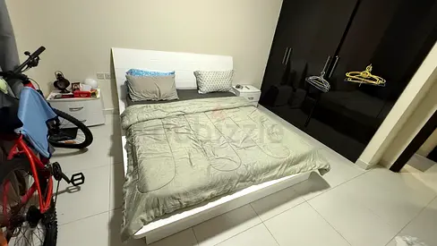 White wooden bed frame with headboard and 2 matching bedside tables. Bed has storage drawers on both