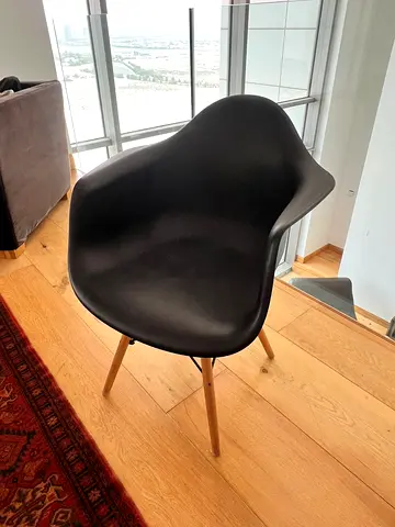 Black Eames-style molded armchair with wooden legs