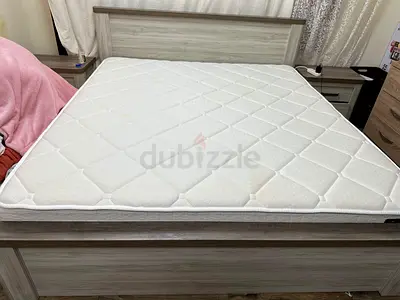 Light grey wooden bed frame with mattress
