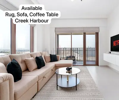 L-shaped beige sofa with rug and coffee table (Creek Harbour)
