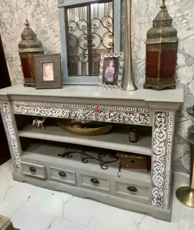 Carved grey wooden entertainment console with drawers and open shelves