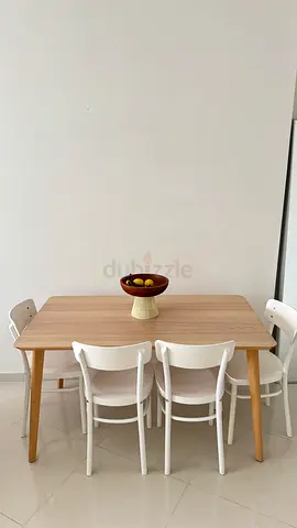 Light wood dining table with 4 white chairs