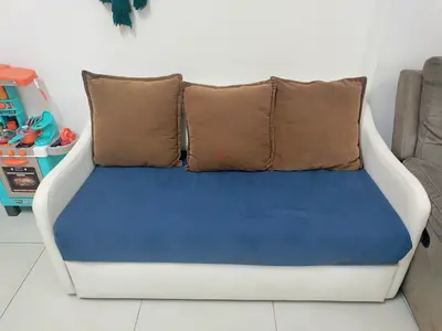 Compact white-frame sofa with blue seat and 3 brown cushions