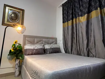 beige queen sized bed with 3 tables, two side tables and one coffee table.
