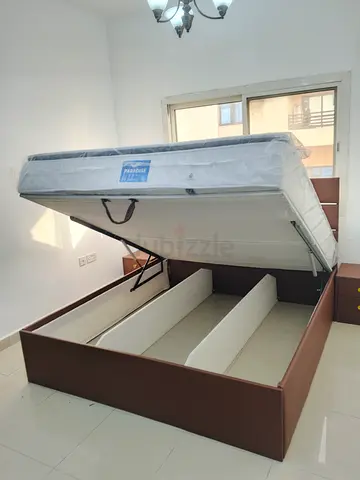 Brown upholstered storage bed with hydraulic lift and mattress
