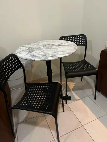 Marble-top bistro table with two black chairs