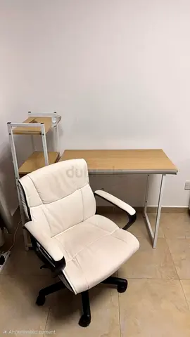 Light wood study desk with white swivel chair and shelving — used