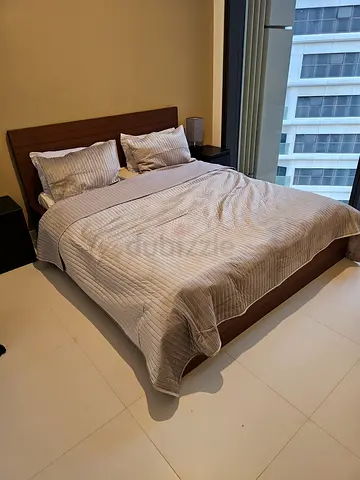 Wooden bed frame with mattress and bedside tables and side lamps in good condition