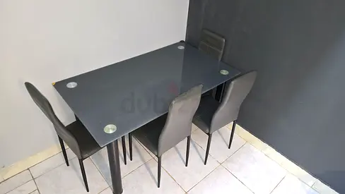 4-Seater Dark Glass Dining Table with Grey Upholstered Chairs