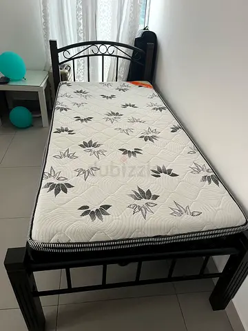 Single black metal bed frame with mattress