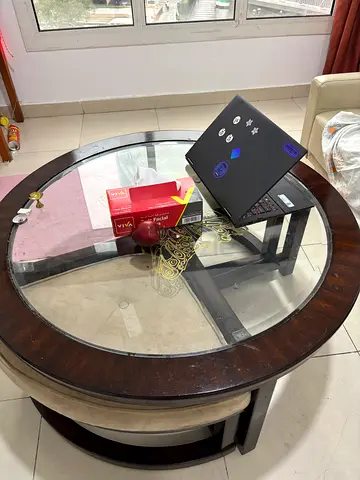 Round wooden coffee table with glass top, used