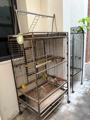 Two large metal bird cages with stands - used