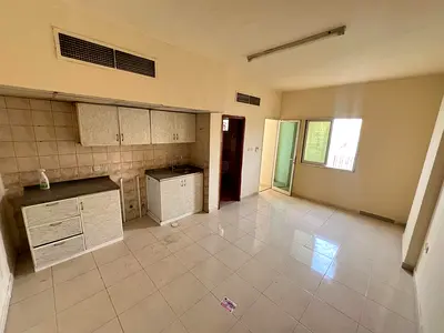 Studio apartment for annual rent in Al Rawda, Ajman. Features include a balcony, spacious area, stunning views, central air conditioning,