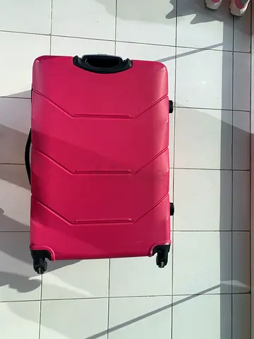 Pink hard-shell wheeled suitcase — good condition