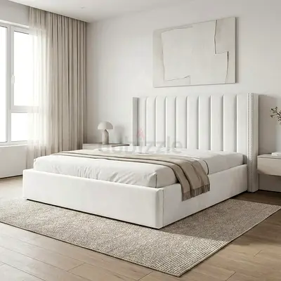 White upholstered platform bed with tall padded headboard