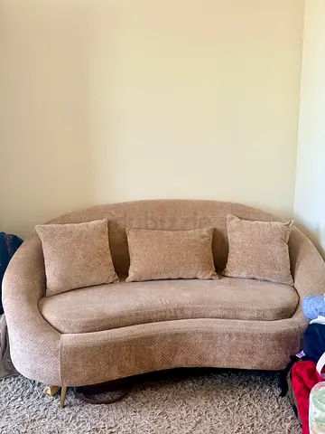 Curved beige sofa with 3 cushions - good condition