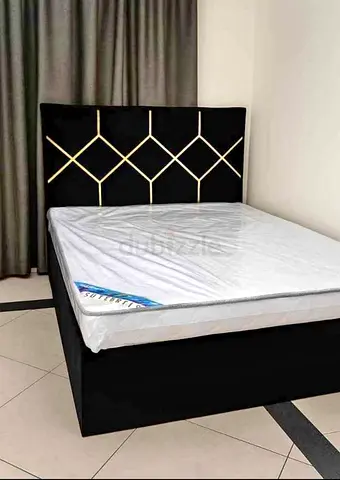 Black upholstered bed frame with geometric headboard + mattress