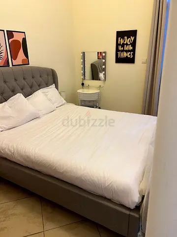 Tufted grey double bed frame with mattress