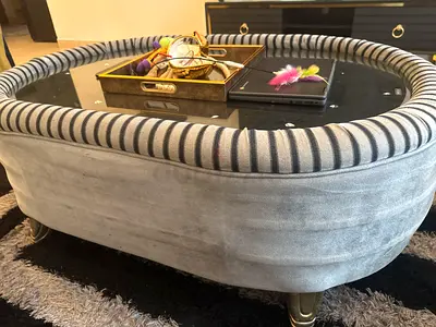 Upholstered oval coffee table with glass top
