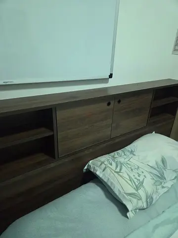 Dark wood headboard with built-in storage shelves and cabinets