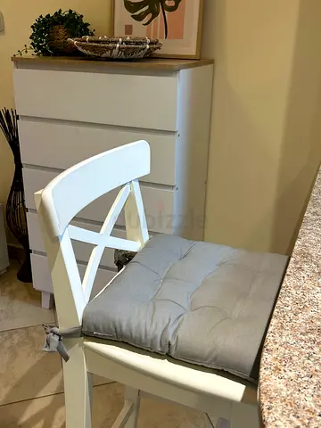 Two White wooden dining chair with gray tufted seat cushion