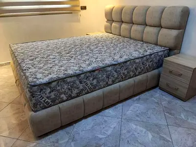 Upholstered bed frame with mattress and bedside table — good condition
