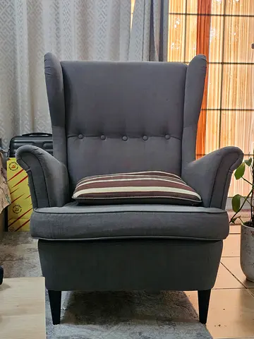 Grey wingback armchair, button-back with solid wood legs — good condition