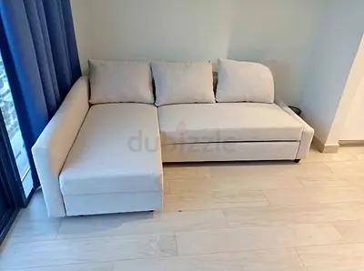 beige L-shaped sofa bed with storage good condition