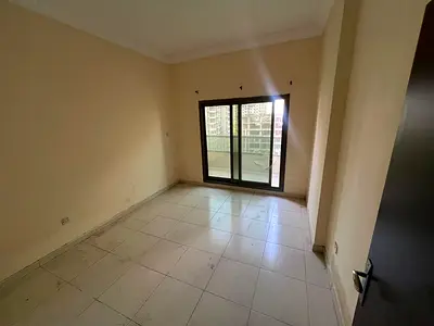 Two-bedroom apartment with a living room for annual rent in Ajman, UAE, overlooking the garden and Mohammed Bin Zayed Road, with a balcony, two bathro