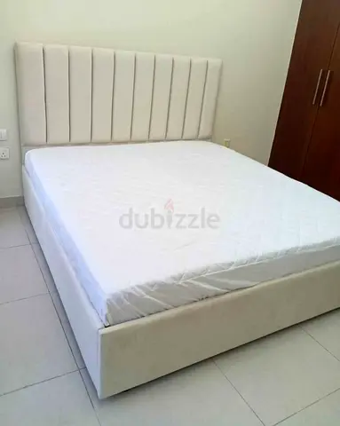 Cream upholstered bed frame with mattress