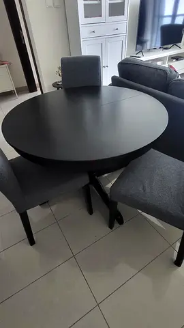 Round black dining table with 3 grey upholstered chairs - good condition