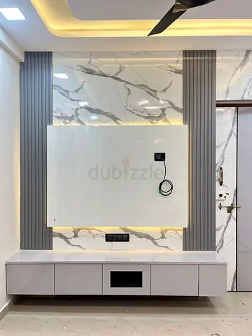 Modern floating TV unit with marble-effect wall panels and LED lighting